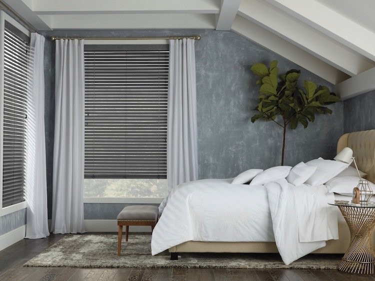 A bedroom with white and darker blue and brown accents