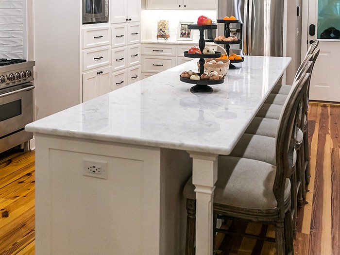 Kitchen island with bar stool seating and electrical outlets.